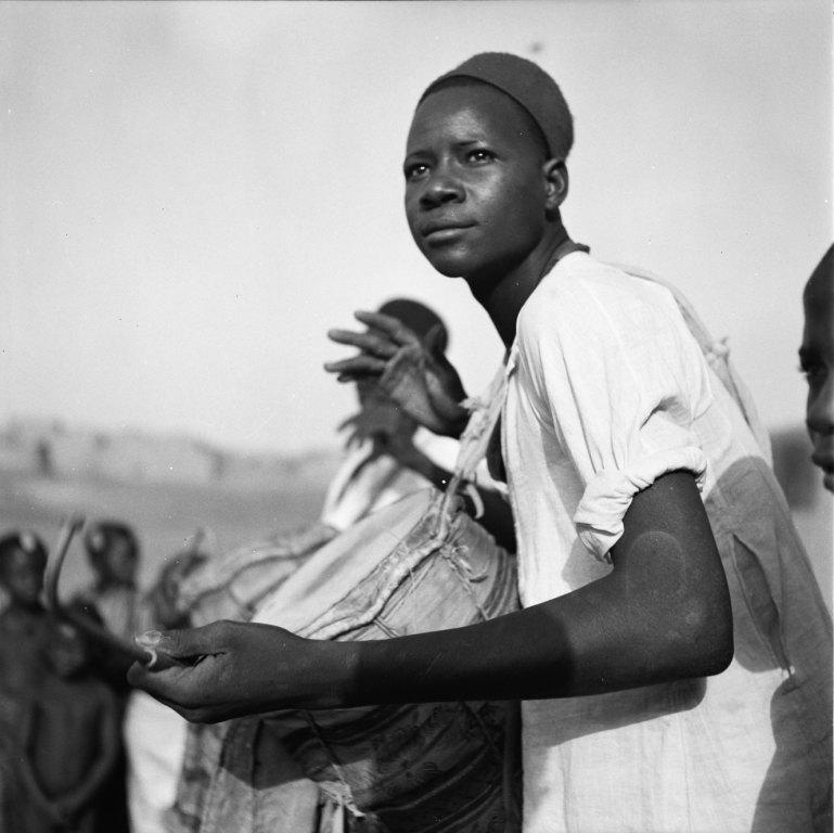Jeune joueur haoussa de tambour ganga. Tahoua (Niger), mars 1953. Photo Jean Gabus, Collection MEN.